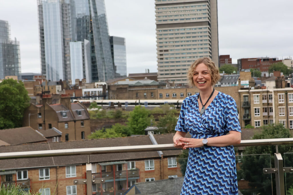 Nicole Osborne standing outside at #WPLDN with the city landscape behind.